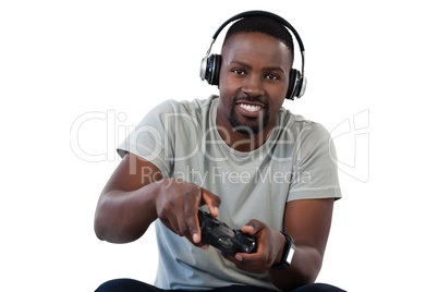 Smiling man playing video game against white background