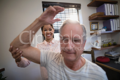 Smiling female doctor looking at senior male patient