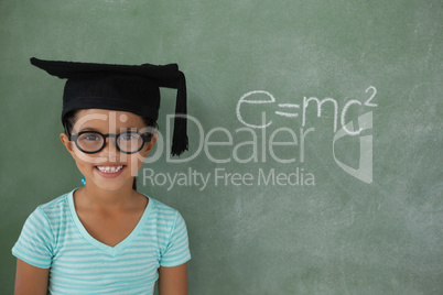 Young girl with graduation hat against chalk board