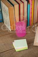 Stack of books, chemical beaker and sticky notes