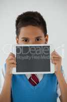 Schoolboy holding digital tablet against white background