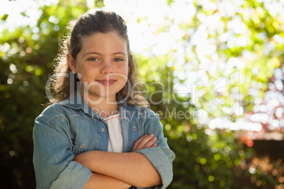 Portrait of confident girl standing with arms crossed