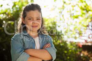 Portrait of confident girl standing with arms crossed