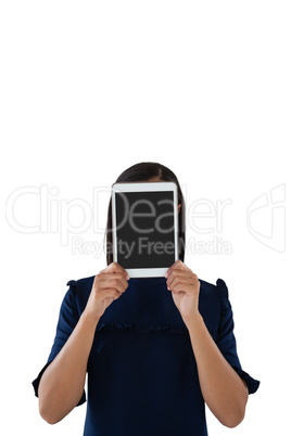 Female executive hiding her face behind digital tablet