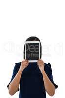 Female executive hiding her face behind digital tablet