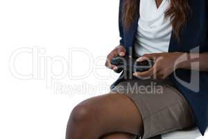 Mid section of businesswoman playing holding controller