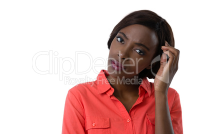 Portrait of confused young woman with hand in hair