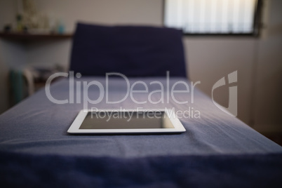 Close-up of digital tablet on blue bed