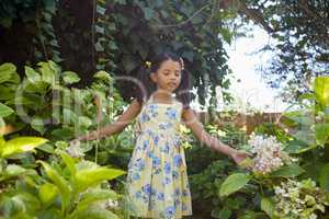 Girl standing amidst green plants