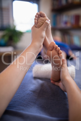 Close-up of boy receiving foot massage from young female therapist