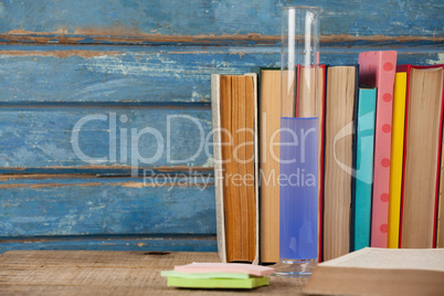 Stack of books, chemical test tube and sticky notes