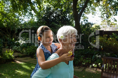 Smiling woman carrying granddaughter with flowers