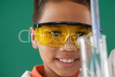 Schoolboy experimenting against green background