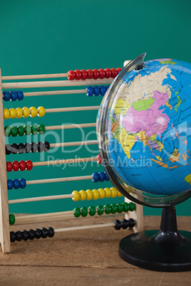 Globe and abacus on wooden table