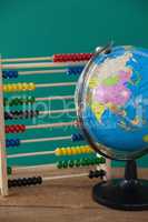 Globe and abacus on wooden table