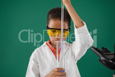 Schoolboy experimenting against green background