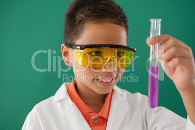 Schoolboy experimenting against green background