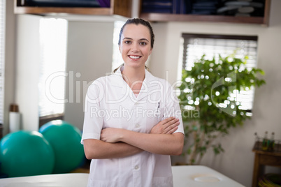 Portrait of smiling female therapist standing with arms crossed