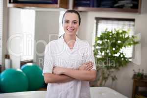 Portrait of smiling female therapist standing with arms crossed
