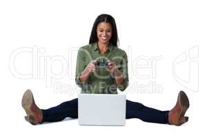 Woman playing video game on laptop against white background