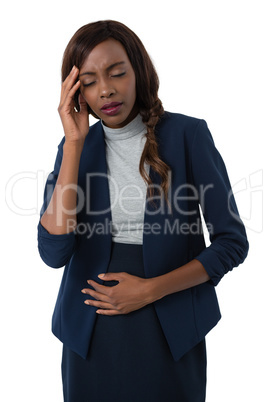 Businesswoman with head in hand suffering from stomach ache
