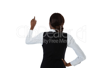 Rear view of businesswoman with hand on hip using invisible interface