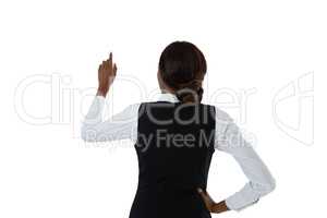 Rear view of businesswoman with hand on hip using invisible interface