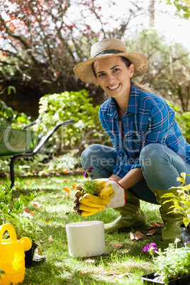 Portrait of smiling woman planting seedling