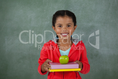 Young girl holding apple and books