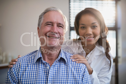 Portrait of smiling female therapist and senior male patient