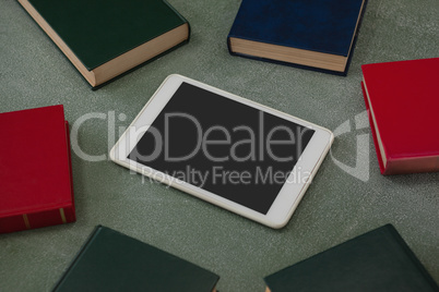 Digital tablet surrounded with colorful organizers on chalkboard