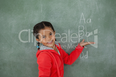 Young girl gesturing over chalk board