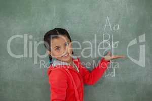 Young girl gesturing over chalk board