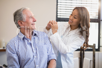 Cheerful female therapist and senior male patient looking at each other