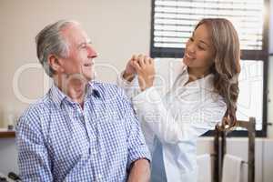Cheerful female therapist and senior male patient looking at each other