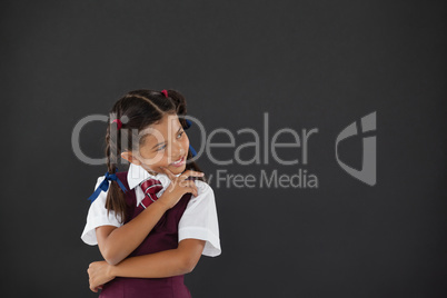 Schoolgirl standing against blackboard in classroom