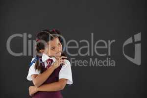 Schoolgirl standing against blackboard in classroom