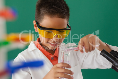 Schoolboy experimenting against green background