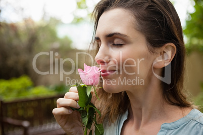 Close-up of beautiful woman with eyes closed smelling pink rose