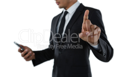 Mid section of businessman using phone while touching invisible interface Mid section of businessman using phone while touching invisible interface