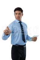 Businessman holding interface while touching invisible screen