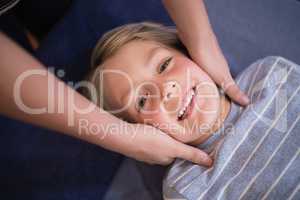 Portrait of smiling boy receiving neck massage from female therapist