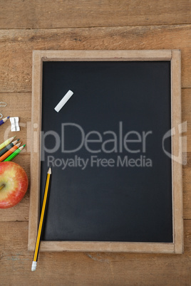 School supplies and apple on wooden table