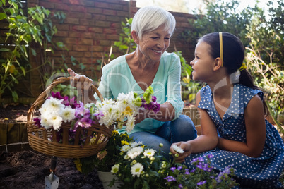 Smiling grandmother with granddaughter holding flower basket