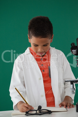 Schoolboy writing on book