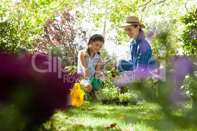 Smiling mother with daughter looking at potted plants