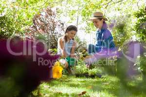 Smiling mother with daughter looking at potted plants