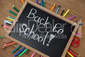 Text written on slate surrounded with school supplies