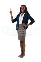Portrait of siling businesswoman with hand on hip giving presentation