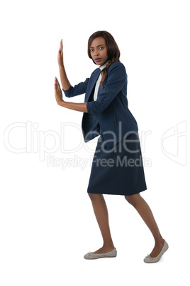 Portrait of businesswoman pushing something on white background